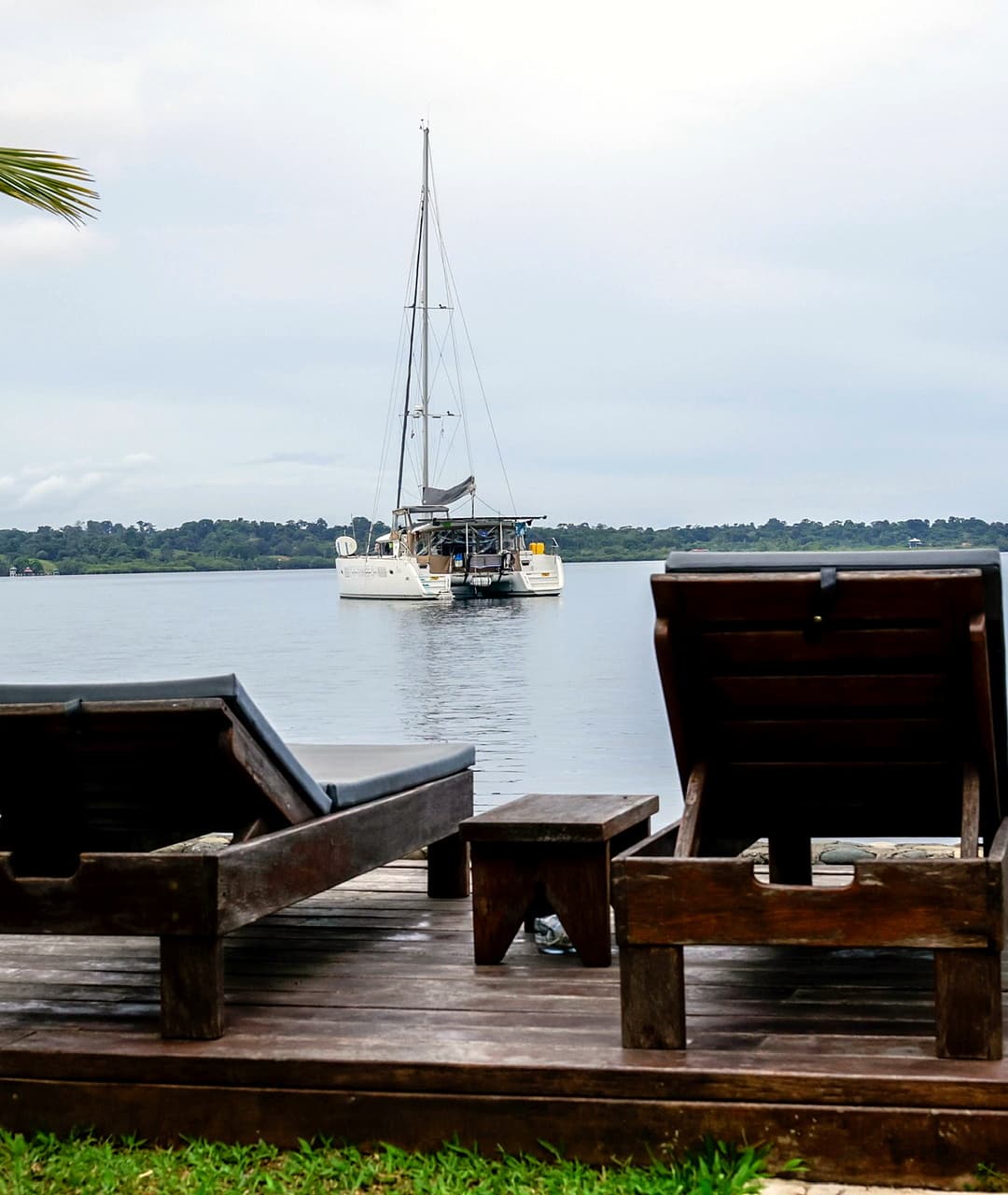 Lounge chairs on waterfront deck with catamaran view at Dolphin Blue Paradise, Bocas del Toro - perfect for sunbathing