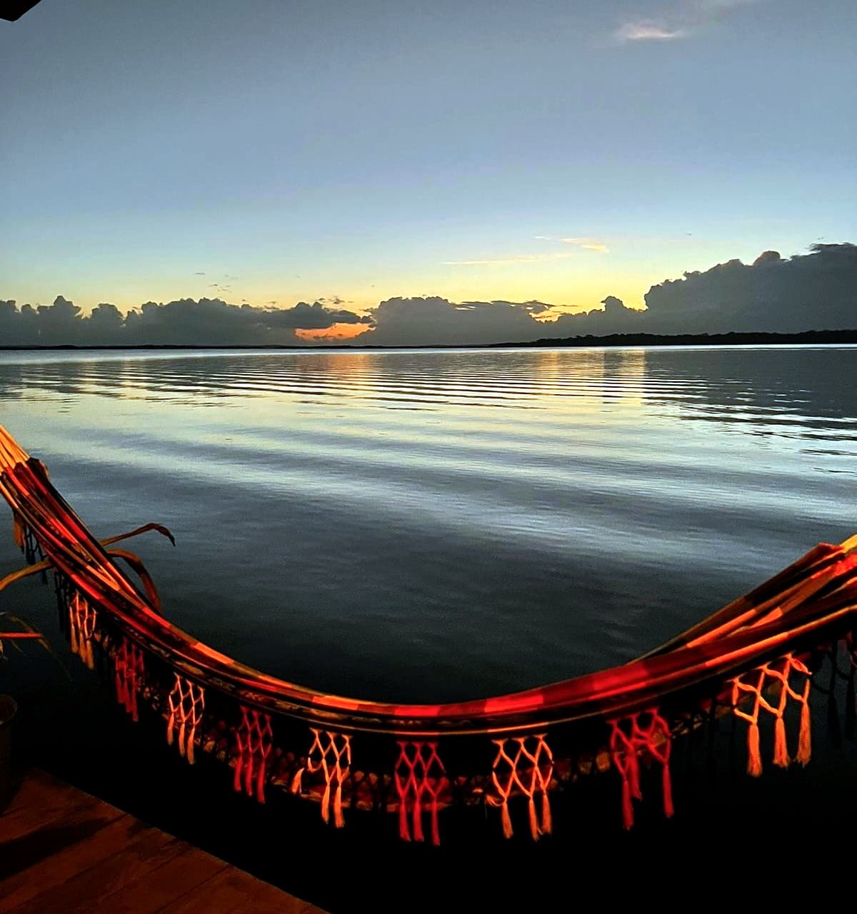 Sunset over Dolphin Bay with hammock on swim platform at Dolphin Blue Paradise, Bocas del Toro - golden hour relaxation