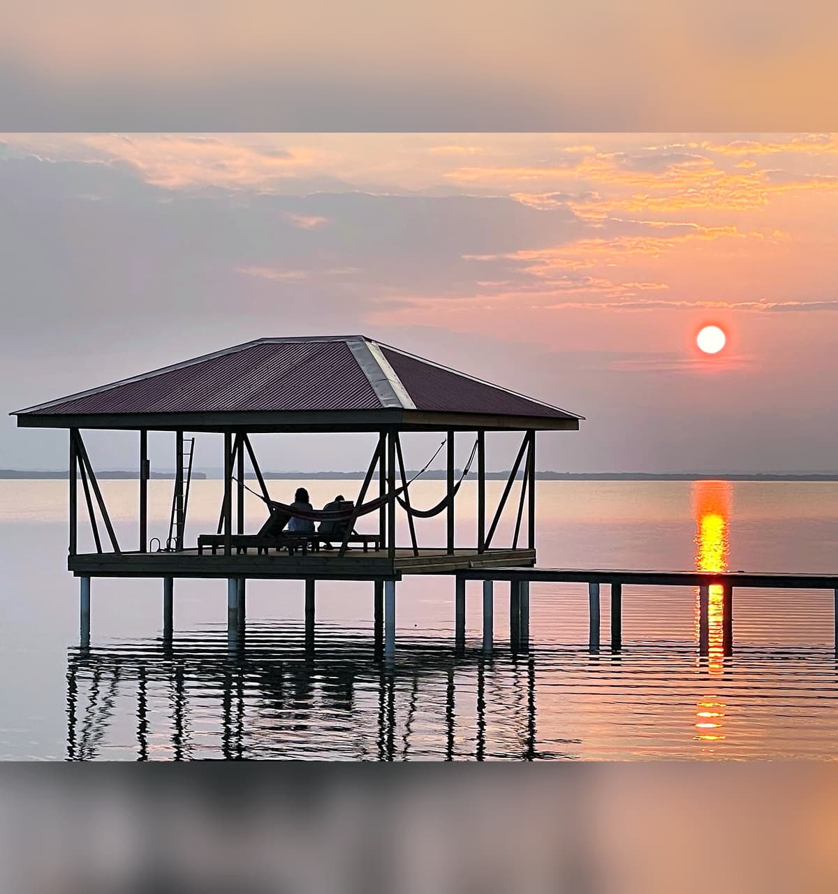Beautiful sunset over swim platform and Dolphin Bay at Dolphin Blue Paradise, Bocas del Toro - golden hour tranquility
